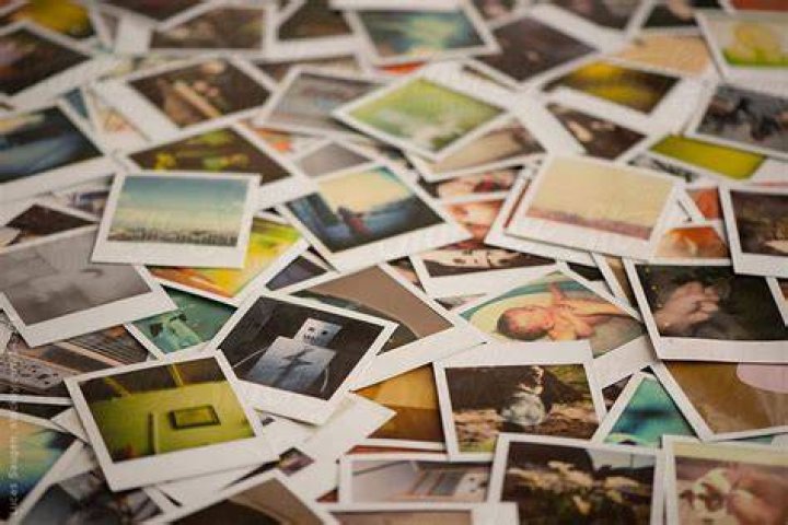 Table Covered In Polaroid Photos. by Lucas Saugen Photography LLC